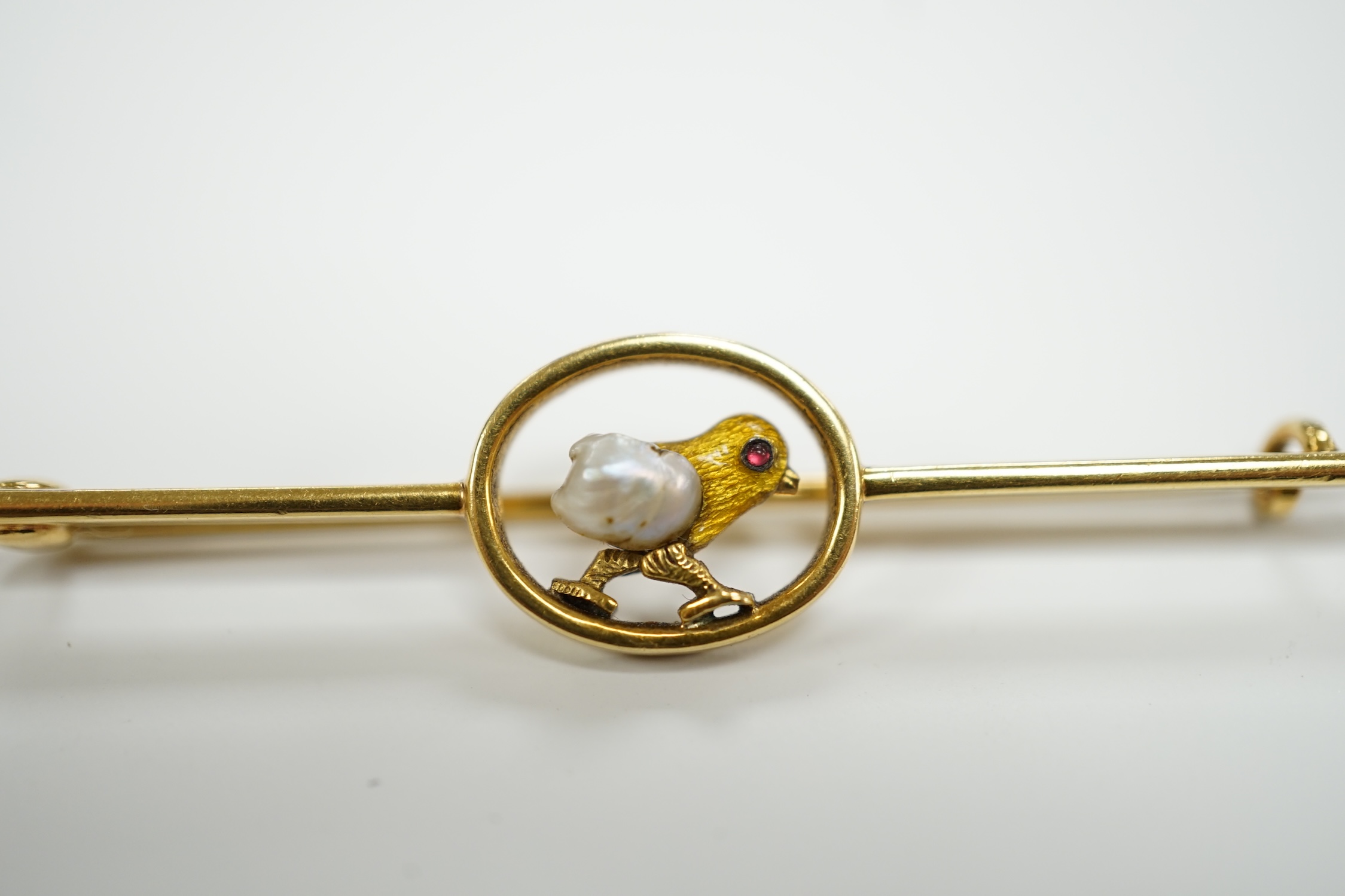 An early 20th century yellow metal, enamel and single stone baroque pearl set bar brooch, modelled as a hatching chick, 50mm, gross weight 3.8 grams.